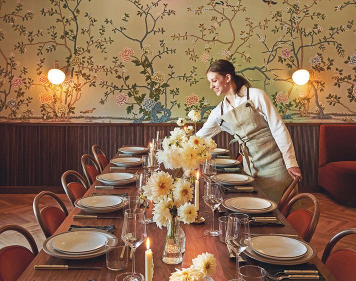Every space in the restaurant is meant for guests to have a different and unique experience, like this particular dining table and elegant floral wallpaper PHOTO BY ANTHONY TAHLIER